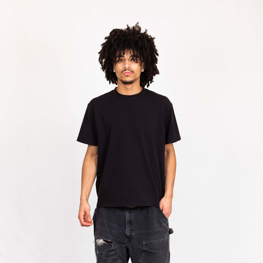 Model wearing Arvin Goods midweight t-shirt in black. Made in USA from recycled and organic cotton.