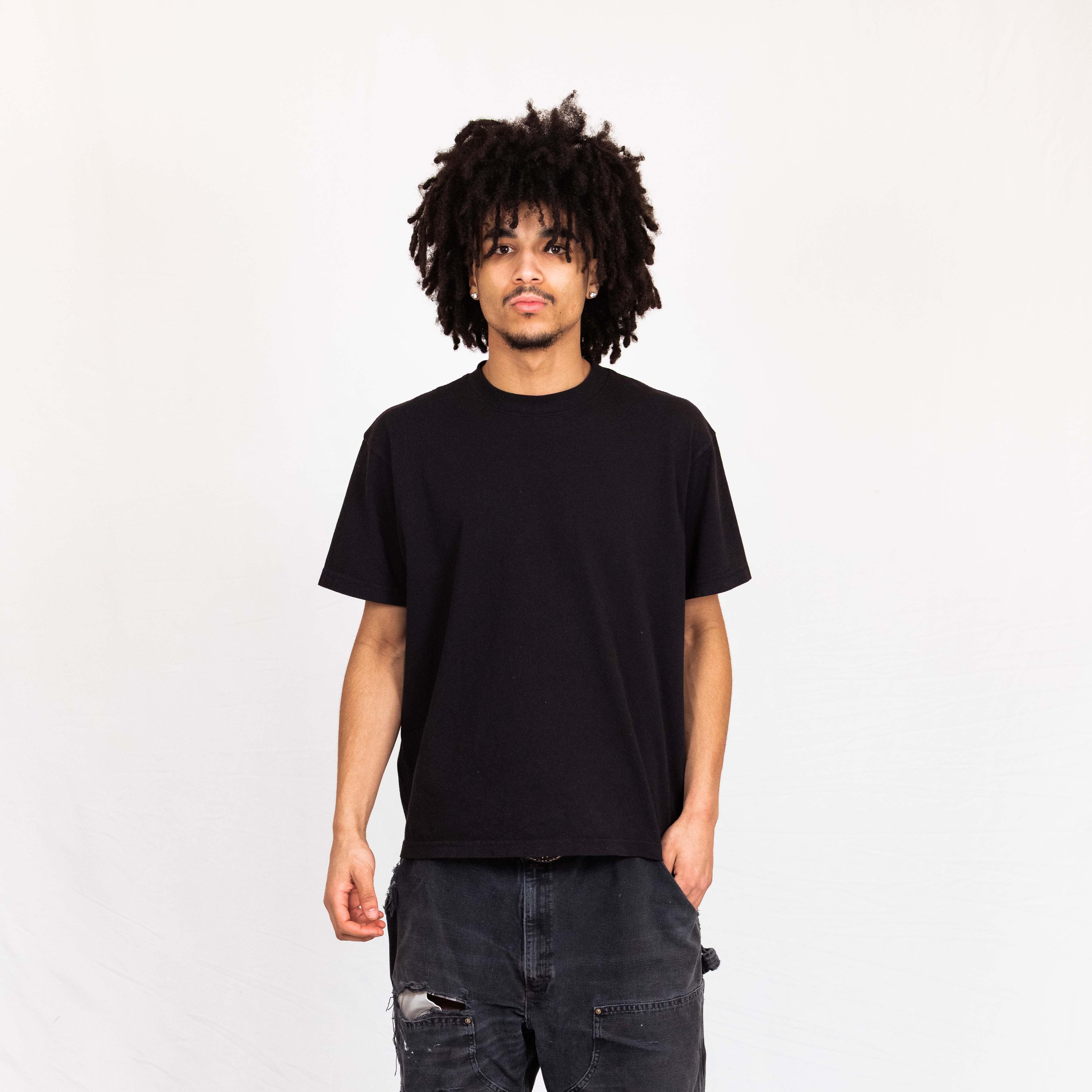 Model wearing Arvin Goods midweight t-shirt in black. Made in USA from recycled and organic cotton.